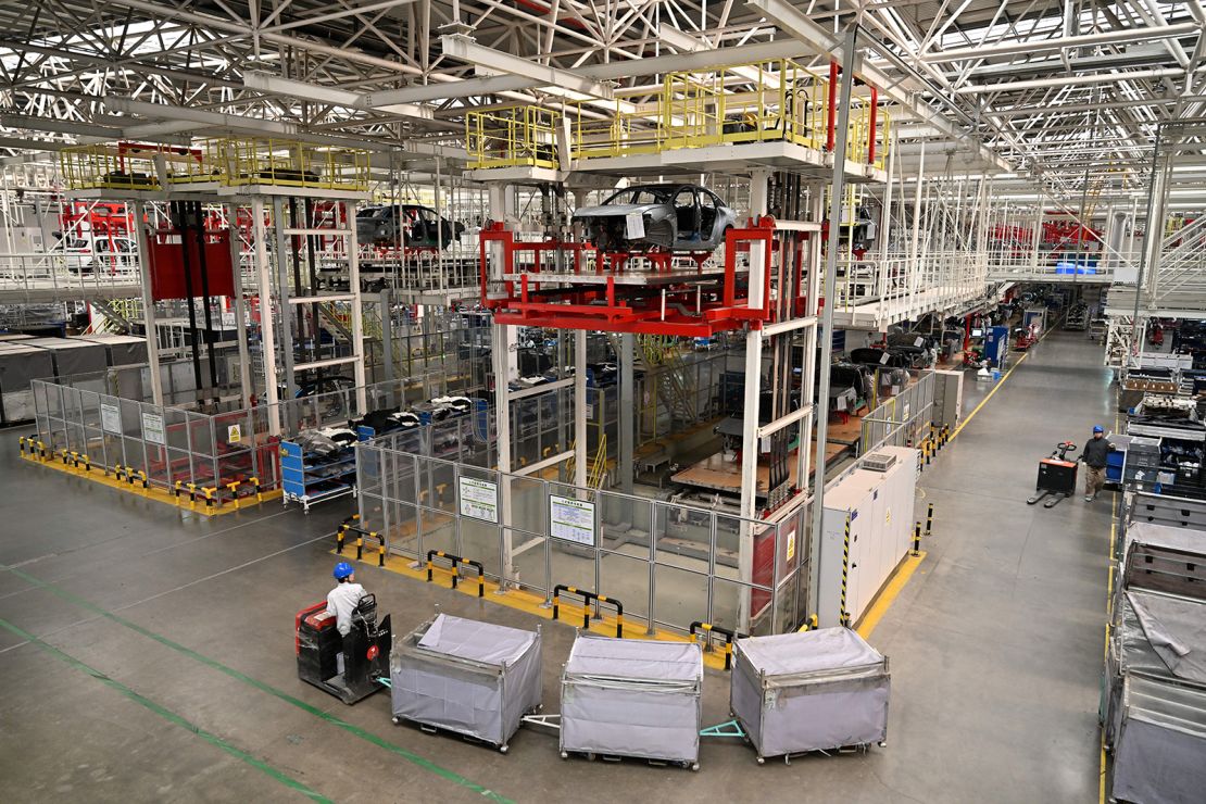 A worker transports parts to the assembly line of electric cars at a Leap Motors plant in Jinhua in east China's Zhejiang province on November 26, 2024.