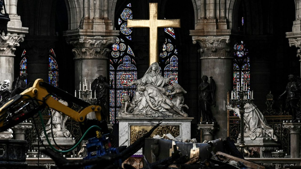 This combination of pictures created on November 29, 2024 shows rubble and the cross at the altar inside the the Notre-Dame Cathedral in Paris a month after it sustained major fire, on May 15, 2019 (TOP), and the tabernacle designed by French artist and designer Guillaume Bardet in the heart of Notre-Dame Cathedral in Paris on November 29, 2024. The Notre-Dame Cathedral is set to re-open early December 2024, with a planned weekend of ceremonies on December 7 and 8, 2024, five years after the 2019 fire which ravaged the world heritage landmark and toppled its spire. Some 250 companies and hundreds of experts were mobilised for the five-year restoration costing hundreds of millions of euros. (Photo by Philippe LOPEZ and STEPHANE DE SAKUTIN / POOL / AFP) / RESTRICTED TO EDITORIAL USE - MANDATORY MENTION OF THE ARTIST UPON PUBLICATION - TO ILLUSTRATE THE EVENT AS SPECIFIED IN THE CAPTION (Photo by PHILIPPE LOPEZSTEPHANE DE SAKUTIN/POOL/AFP via Getty Images)