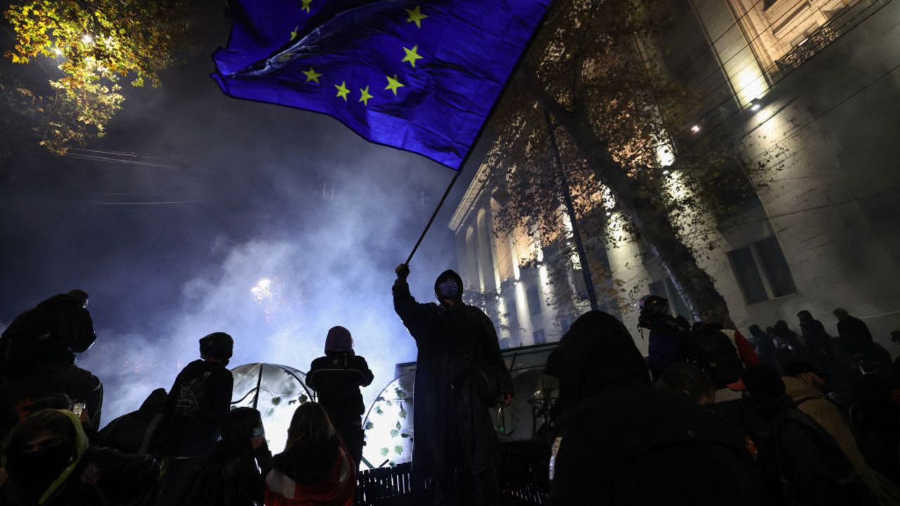 TOPSHOT - An activist waves a European Union flag as he takes part to a demonstration against the government's decision to delay EU membership talks, near the Parliament building in downtown Tbilisi early on November 30, 2024. Georgian police fired water cannon and tear gas on demonstrators on the second day to protest the government putting off EU membership talks. The Black Sea nation has been rocked by turmoil since the ruling Georgian Dream party declared victory in last month parliamentary elections that the pro-EU opposition decried as falsified. (Photo by Giorgi ARJEVANIDZE / AFP) (Photo by GIORGI ARJEVANIDZE/AFP via Getty Images)