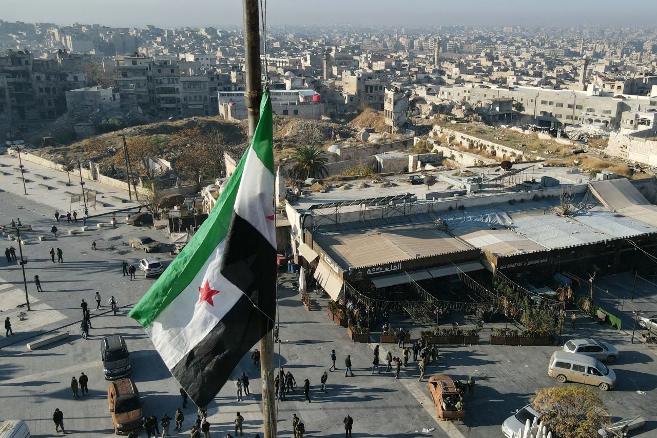 On November 30, a Syrian opposition flag flies over a marketplace in central Aleppo