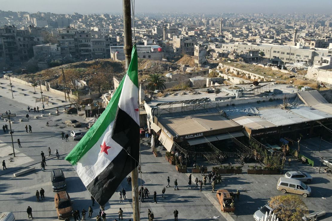 a syrian opposition flag above a market square in central aleppo on november 30, 2024.