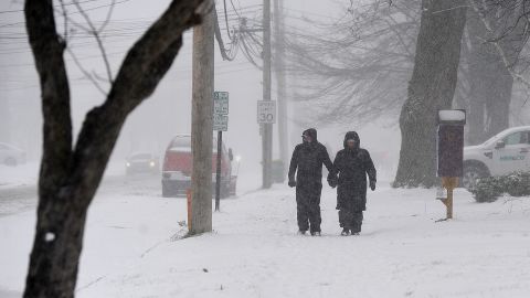 A couple makes their way through lake effect snow to attend the annual Hamburg Holiday Parade in Hamburg, New York, on November 30, 2024. The Northeast storm that closed a 90 mile stretch of The New York State Thruway and snarled holiday traffic across the country dumped more than four feet of snow around Buffalo and its southern suburbs and is expected to continue throughout the weekend.