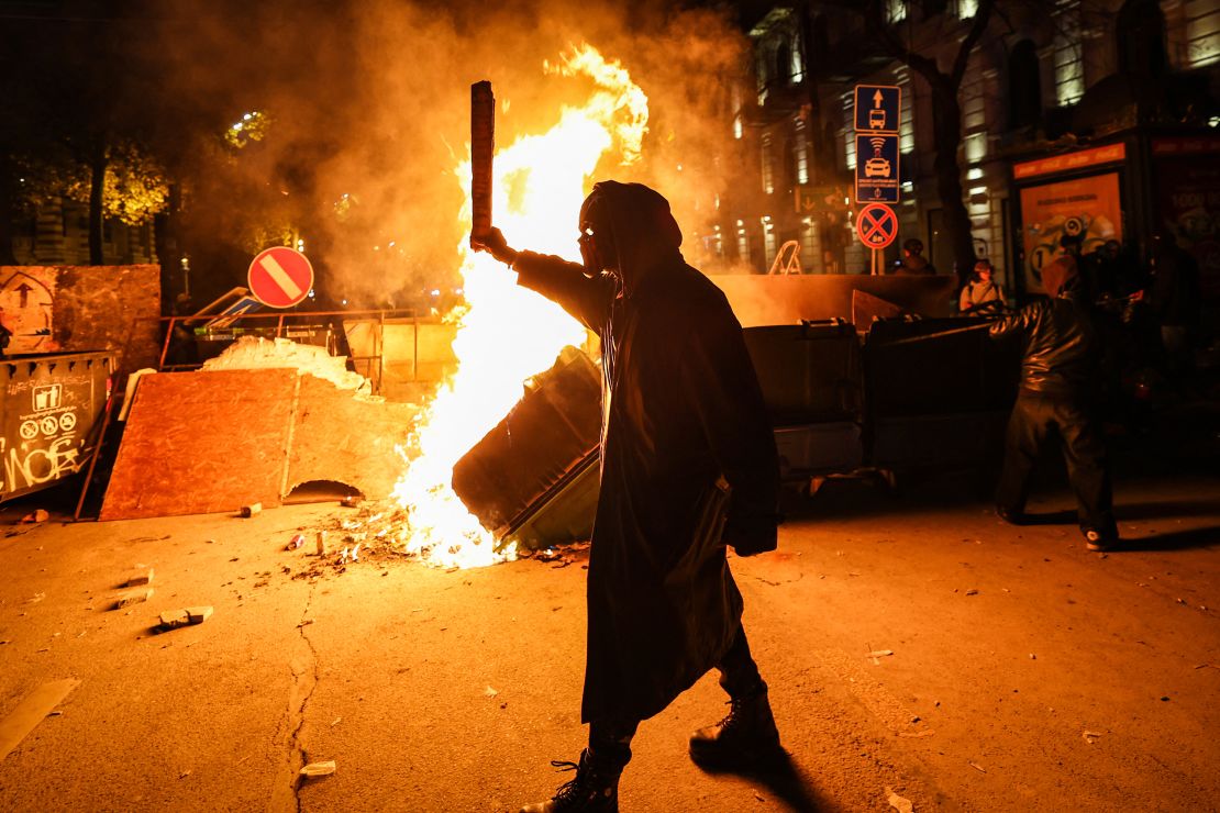 Protesters light a fire at the base of a makeshift barricade erected in a street in Tbilisi during demonstrations early on December 1, 2024.