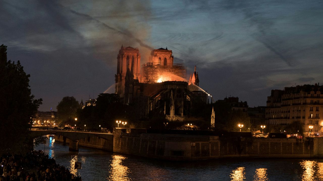 This combination of pictures created on November 29, 2024 shows (top) Firefighters douse flames billowing from the roof of Notre-Dame Cathedral in Paris on April 15, 2019 and (bottom) Notre-Dame de Paris cathedral a few days before its reopening, in central Paris on November 26, 2024. The Notre-Dame Cathedral is set to re-open early December 2024, with a planned weekend of ceremonies on December 7 and 8, 2024, five years after the 2019 fire which ravaged the world heritage landmark and toppled its spire. Some 250 companies and hundreds of experts were mobilised for the five-year restoration costing hundreds of millions of euros.