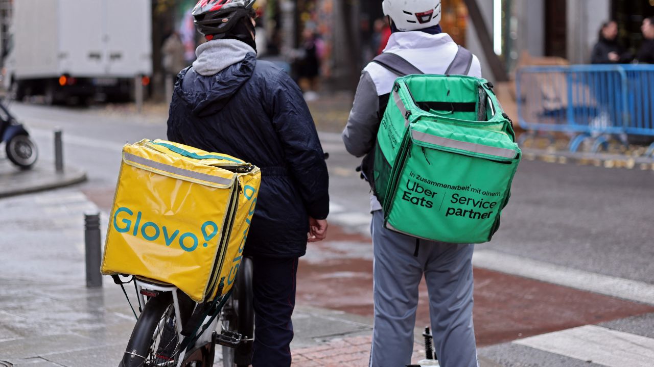 A food delivery firm Glovo's rider chats with an Uber Eats' rider in Madrid on December 2, 2024. Following a Spanish government pressure, Glovo company in Spain gives to their employees a labour contract. "Glovo management decided to change from a freelance model to an employment based model for its delivery riders in Spain to avoid further legal uncertainties leading to an increase of contingencies" Glovo's German owners Delivery Hero said in a statement on December 2, 2024. Spain in 2021 became the first European Union (EU) nation to give food delivery riders labour rights, requiring that they be recognised as employees instead of being considered self-employed freelancers. (Photo by Thomas COEX / AFP) (Photo by THOMAS COEX/AFP via Getty Images)