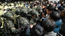 Soldiers try to enter the National Assembly building in Seoul on December 4 2024, after South Korea President Yoon Suk Yeol declared martial law. South Korea's President Yoon Suk Yeol on December 3 declared martial law, accusing the opposition of being "anti-state forces" and saying he was acting to protect the country from "threats" posed by the North. (Photo by Jung Yeon-je / AFP) (Photo by JUNG YEON-JE/AFP via Getty Images)