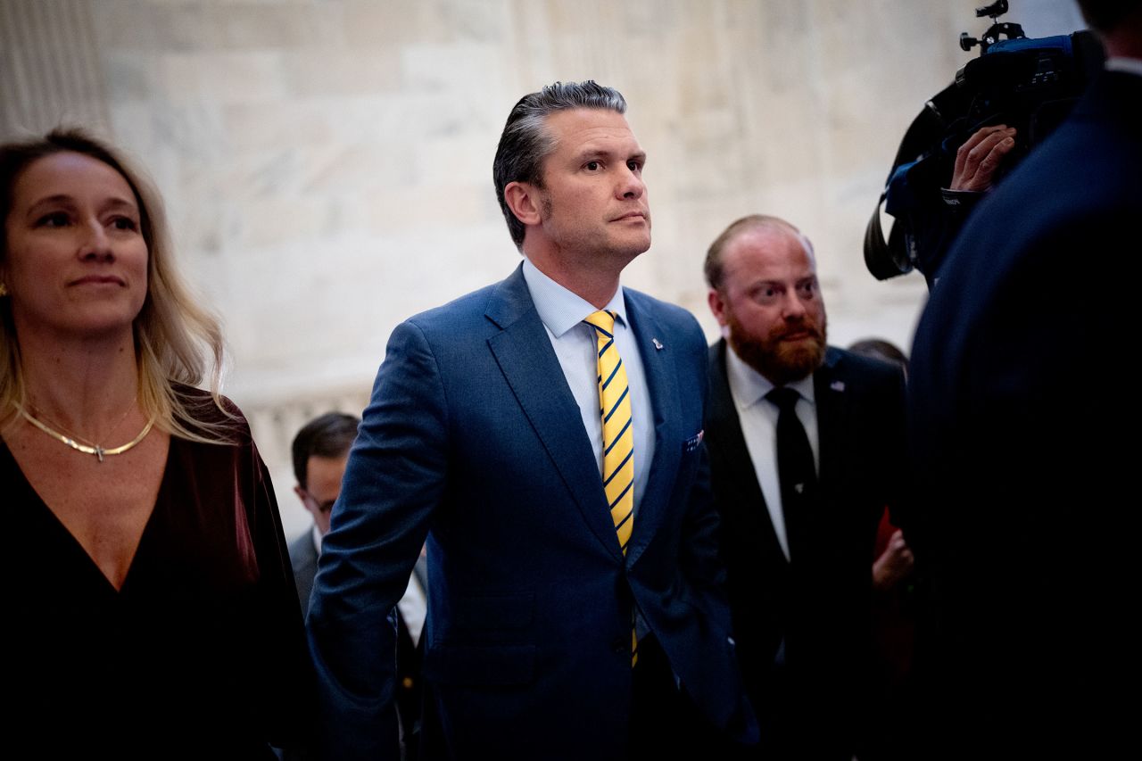 Pete Hegseth and his wife Jennifer Rauchet, left, walk through the Russell Senate Office building on Capitol Hill on Tuesday.