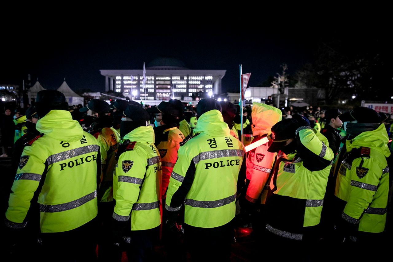 Police officers attempt to clear protesters as they occupy the street outside the National Assembly in Seoul, South Korea, early on Wednesday, December 4.