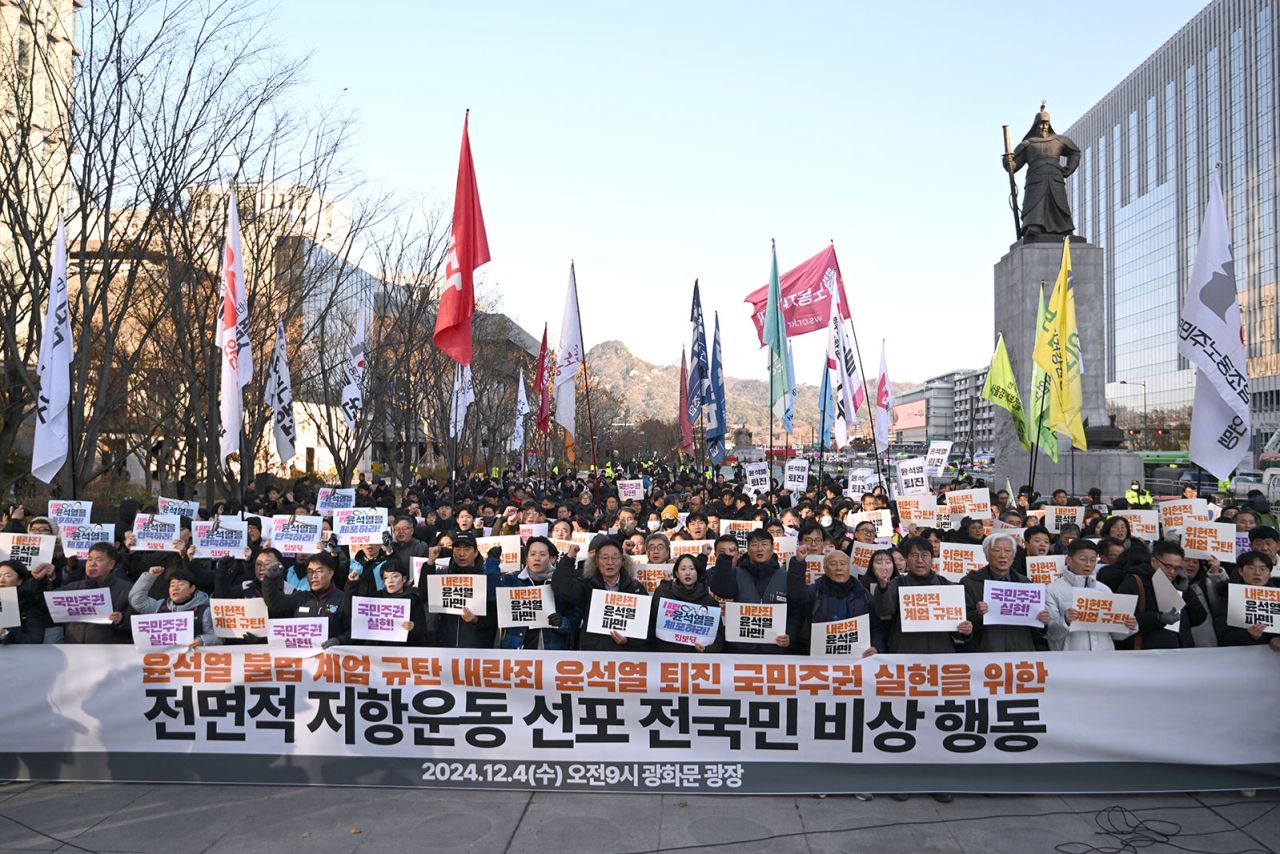 South Korean protesters hold a banner that reads "we condemn Yoon Suk Yeol's illegal martial law" during a rally against President Yoon Suk Yeol at Gwanghwamun Square in Seoul on December 4.