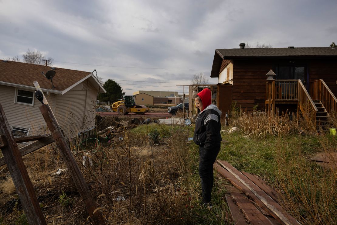 Morgan Speichinger walks through the backyards of her neighbors' destroyed homes five months after a June 23 flood near McCook Lake in North Sioux City, South Dakota.