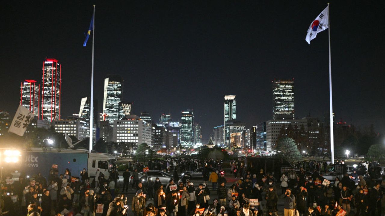 People gather for a protest against South Korea President Yoon Suk Yeol on the grounds of the National Assembly in Seoul on December 4, 2024. Thousands marched on parliament in South Korea's capital on December 4, joining a bid by the country's opposition to impeach President Yoon Suk Yeol after his extraordinary but short-lived imposition of martial law. (Photo by Anthony WALLACE / AFP) (Photo by ANTHONY WALLACE/AFP via Getty Images)