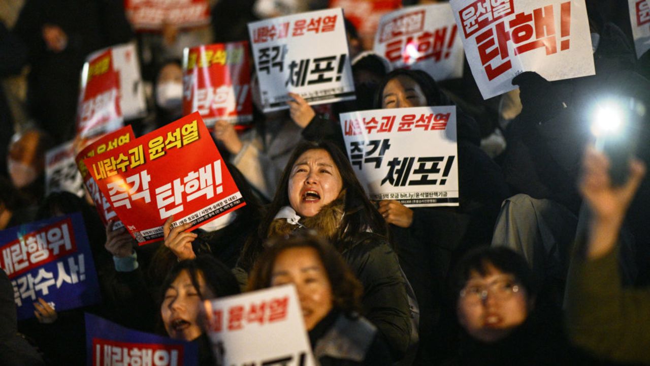 TOPSHOT - People take part in a protest calling for the resignation of South Korea President Yoon Suk Yeol at the National Assembly in Seoul on December 4, 2024. Thousands marched on parliament in South Korea's capital on December 4, ing a bid by the country's opposition to impeach President Yoon Suk Yeol after his extraordinary but short-lived imposition of martial law. (Photo by Anthony WALLACE / AFP) (Photo by ANTHONY WALLACE/AFP via Getty Images)