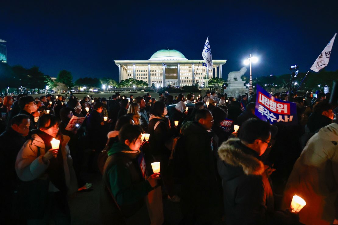 People protesting against South Korean president Yoon Suk Yeol chant slogans as they attend a candlelight rally outside the National Assembly Building, in Seoul, South Korea, on 04 December, 2024.