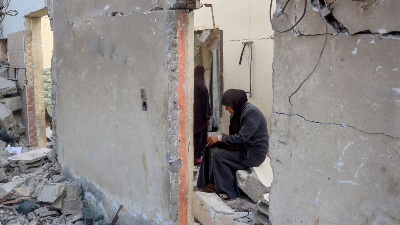 A woman sits amidst the rubble of a building after an Israeli strike in Nuseirat in the central Gaza Strip on December 5, 2024, as the war between Israel and Hamas militants continues. (Photo by Eyad BABA / AFP) (Photo by EYAD BABA/AFP via Getty Images)