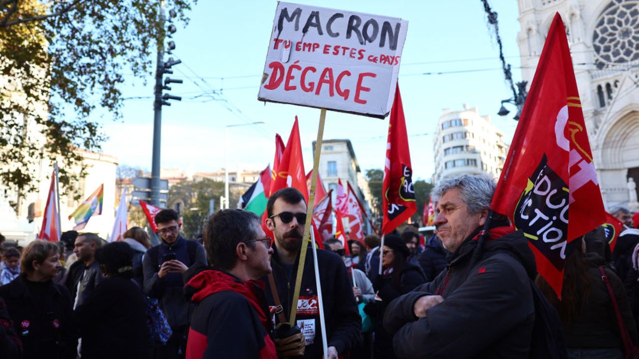 A protester holds a placard reading "(French President) Macron, you stink, get out" during a rally in Marseille on December 5, 2024, as part of a day of action and strike in the public sector. Civil servants in are mobilizing on December 5, 2024 for a day of action and strikes called by public service unions to open up a social front in the midst of a political crisis, the day after Michel Barnier's government fell on a motion of no-confidence. (Photo by Clement MAHOUDEAU / AFP) (Photo by CLEMENT MAHOUDEAU/AFP via Getty Images)