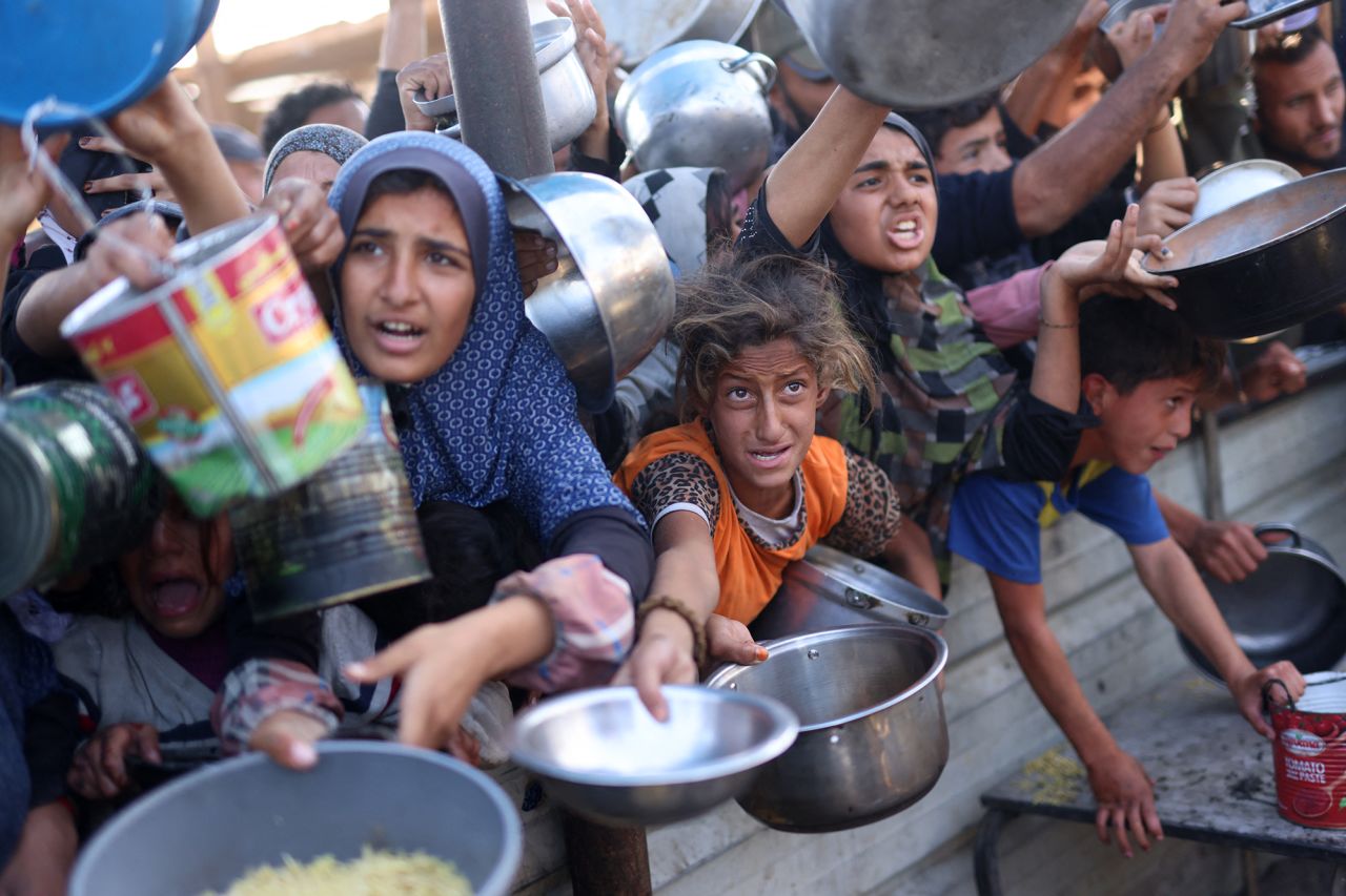 Palestinians wait in a queue to receive food outside a distribution center south of Khan Younis, Gaza, on December 6.