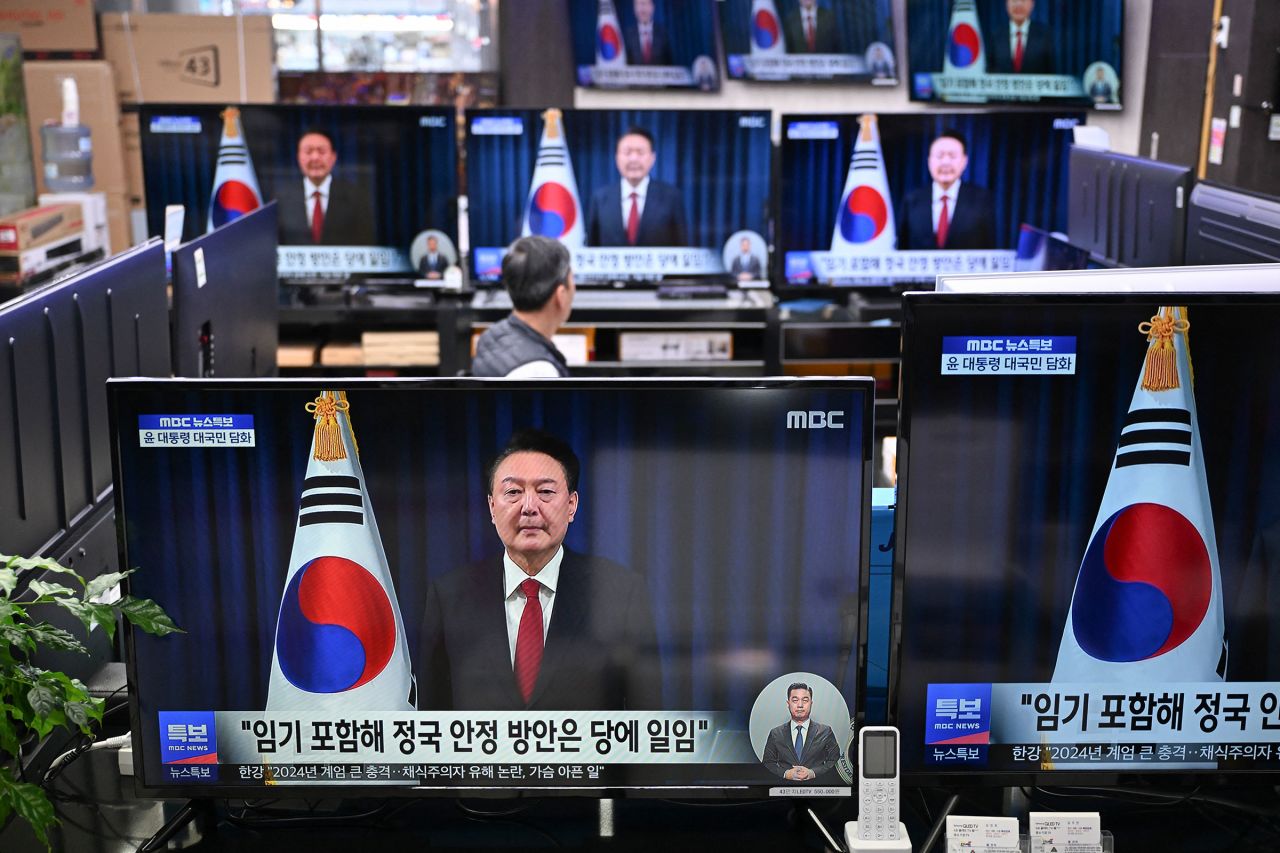 Television screens show live footage of an address by South Korea's President Yoon Suk Yeol at an electronic market in Seoul on December 7. Yoon apologized for the confusion caused by his declaration of martial law