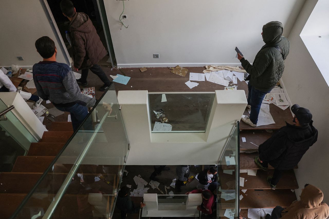 People enter the residence of Syria's ousted president Bashar al-Assad in Damascus on December 8.