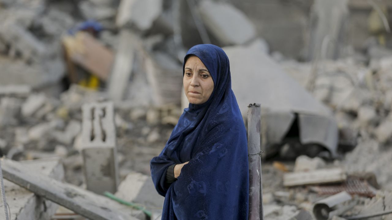 A woman surveys the rubble of destroyed buildings in the Nuseirat refugee camp, central Gaza Strip, on December 7, 2024. Following Israeli airstrikes, the Nuseirat refugee camp in Gaza has been left in devastation. (Photo by Moiz Salhi / Middle East Images / Middle East Images via AFP) (Photo by MOIZ SALHI/Middle East Images/AFP via Getty Images)