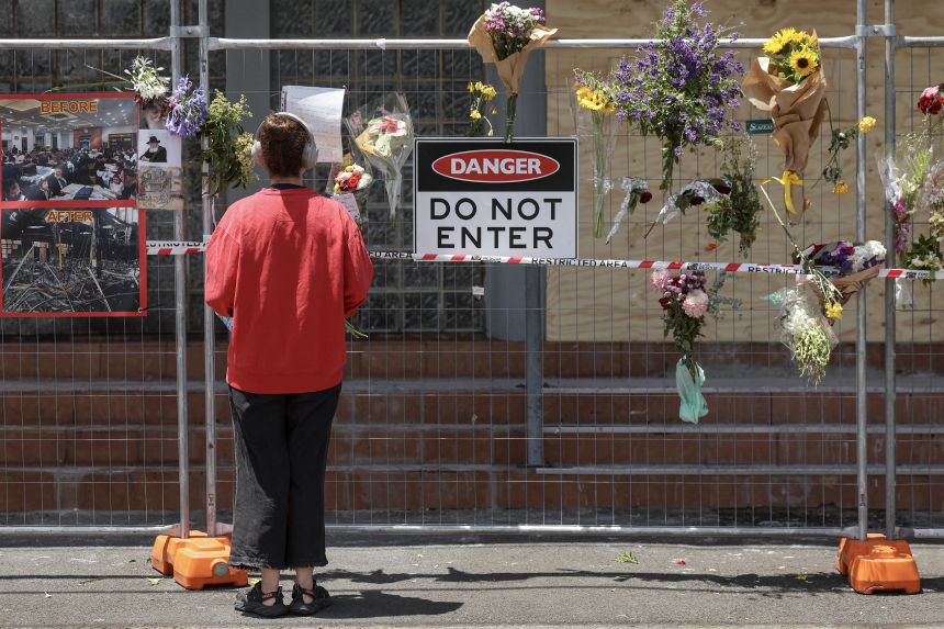 A visitor reads messages attached to a fence where flowers have been left at the Adass Israel Synagogue in the Melbourne suburb of Ripponlea on December 9, 2024.