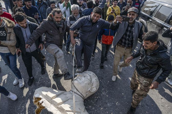 Citizens in Syria take down statues of Hafez al-Assad, the father of Bashar al-Assad, in Damascus, on December 9.