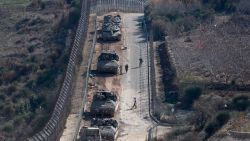 Israeli tanks and armoured vehicles line up the area outside the Druze village of Majdal Shams on the fence with the buffer zone that separates the Israeli-annexed Golan Heights from the rest of Syria on December 9, 2024. Israel's Foreign Minister Gideon Saar said on December 9 that his country's military takeover of the buffer zone along its border with Syria was a "limited and temporary step" after Prime Minister Benjamin Netanyahu announced the previous day that he had ordered the army to "take control" of the zone, following the fall of Syrian president Bashar al-Assad. (Photo by Menahem KAHANA / AFP) (Photo by MENAHEM KAHANA/AFP via Getty Images)