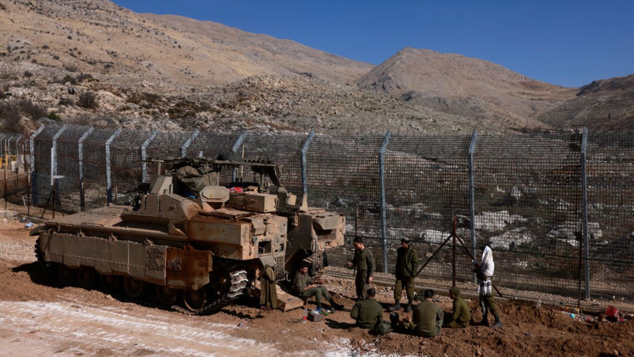 Israeli troops deploy at the buffer zone that separates the Israeli-annexed Golan Heights from Syria, on December 9, 2024, near the Druze village of Majdal Shams. Israel's Foreign Minister Gideon Saar said on December 9 that his country's military takeover of the buffer zone along its border with Syria was a "limited and temporary step" after Prime Minister Benjamin Netanyahu announced the previous day that he had ordered the army to "take control" of the zone, following the fall of Syrian president Bashar al-Assad. (Photo by Menahem Kahana / AFP) (Photo by MENAHEM KAHANA/AFP via Getty Images)