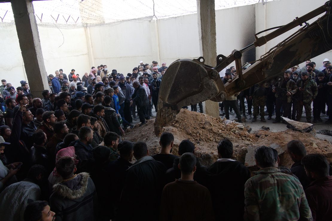 People wait as the volunteer group Syrian Civil Defense investigated the inside of Saydnaya Prison after the fall of the Assad regime in Syria on December 9, 2024.