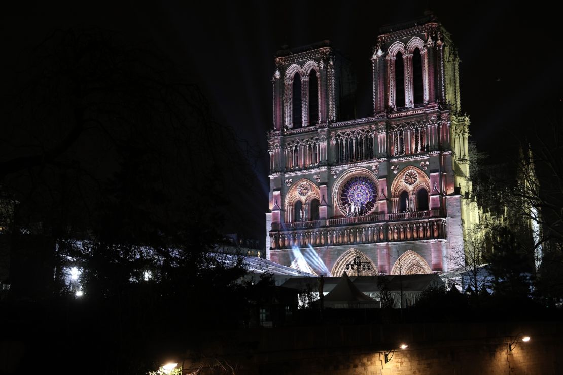 A light show is projected on the facade of Notre Dame.