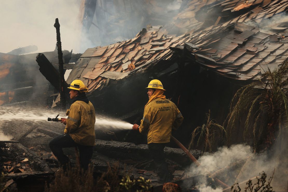 Firefighters spray water as the Franklin Fire grows in Malibu, California, on Tuesday.