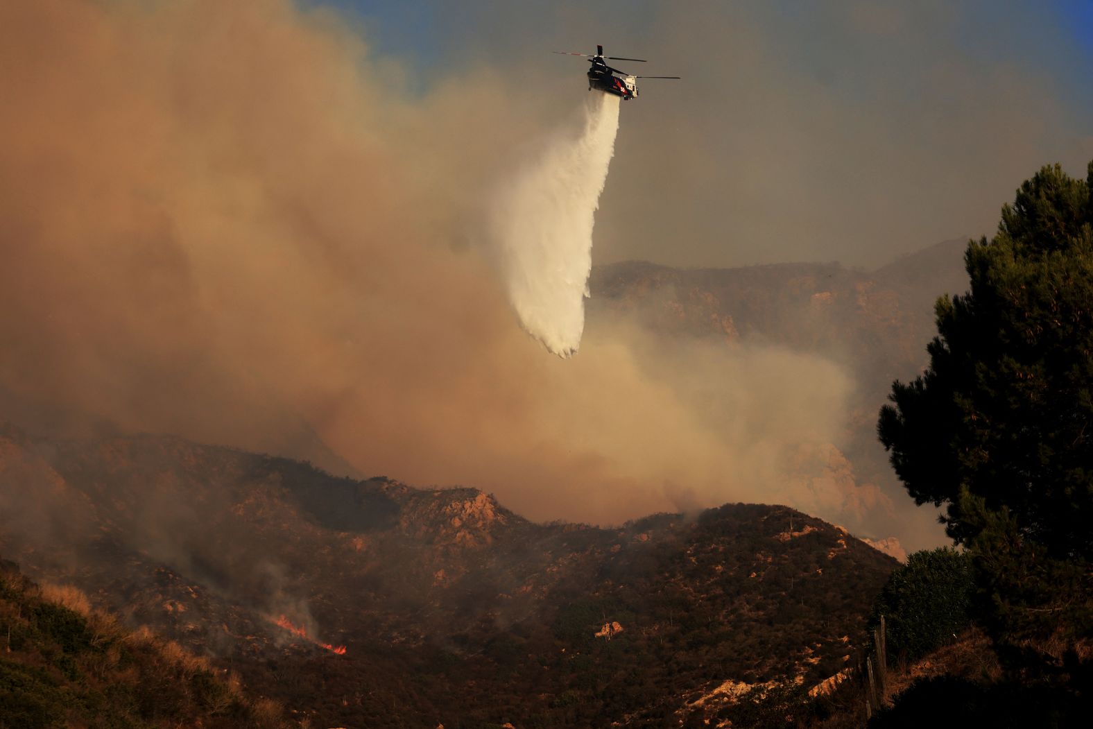 A helicopter drops water on the wildfire on Tuesday.