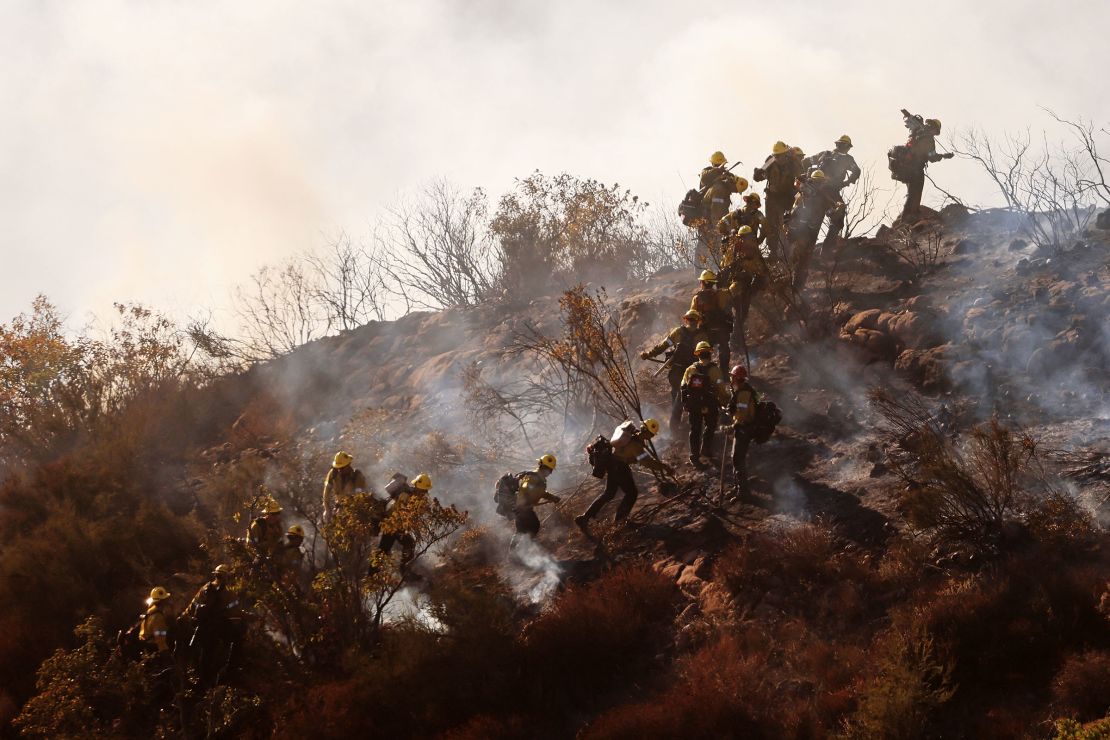 Hotshots climb a ridge as a mountainside burns as the Franklin Fire breaks out in Malibu, California on Tuesday.