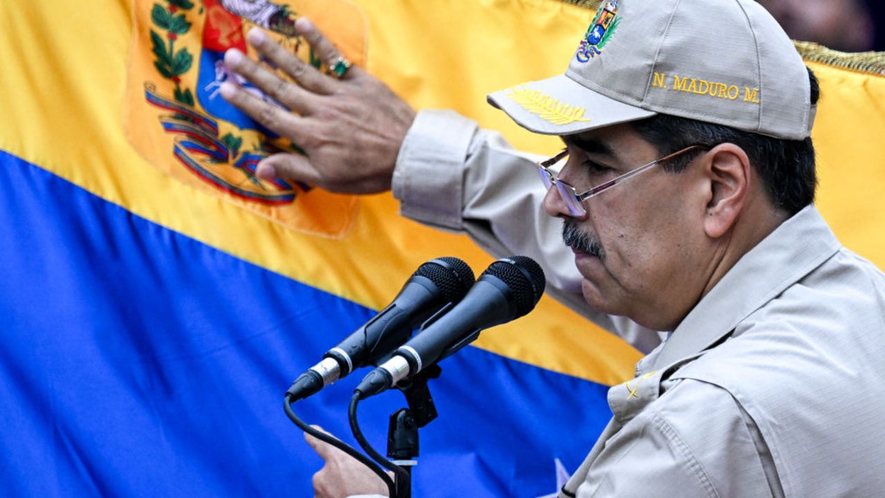 Venezuela's President Nicolas Maduro touches a Venezuelan flag as he speaks during an event marking the 165th anniversary of the Battle of Santa Ines in Caracas on December 10, 2024. (Photo by Juan BARRETO / AFP) (Photo by JUAN BARRETO/AFP via Getty Images)