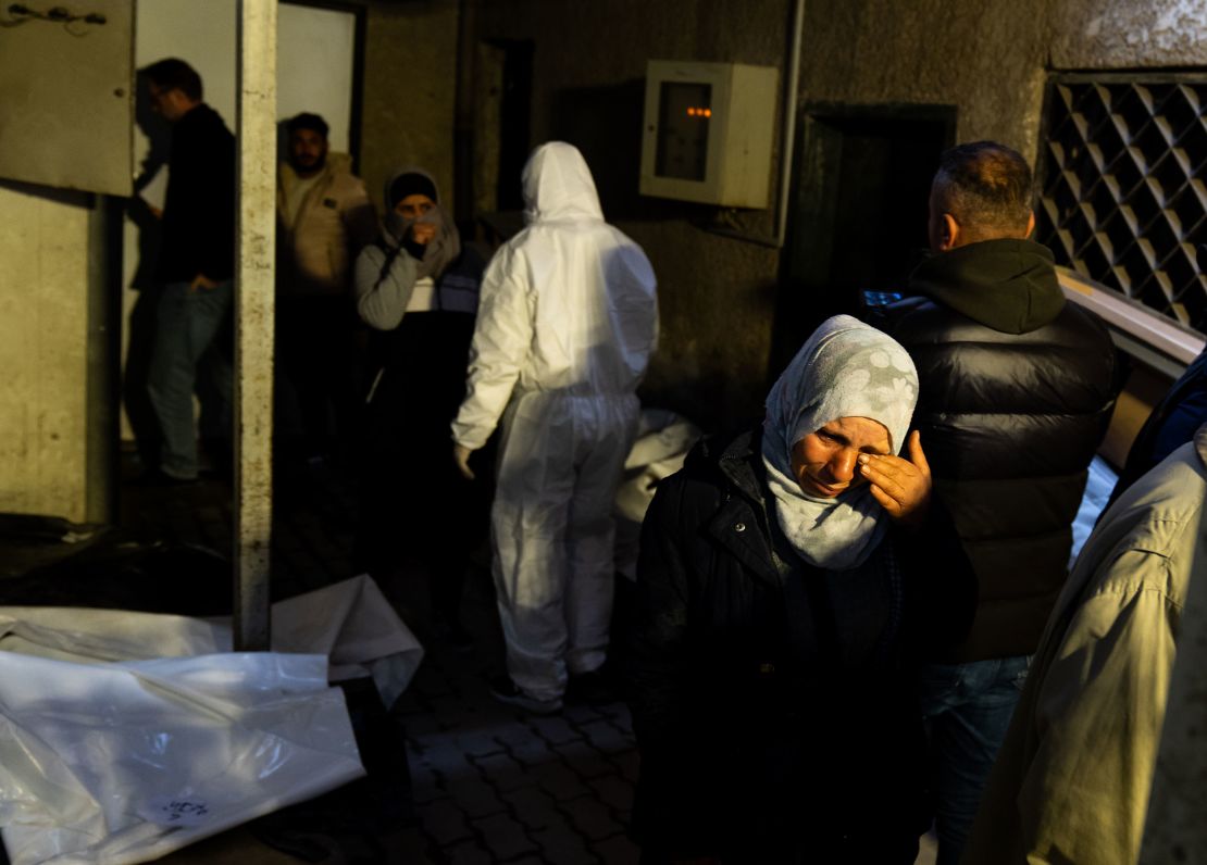 A woman reacts as people searching for missing family members gather outside at Al Mujtahid Hospital in Damascus on December 11 to identify bodies who were tortured to death by the Assad regime.