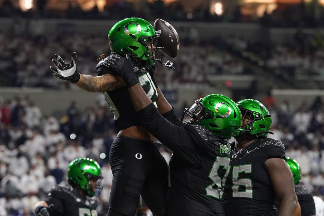 Jordan James of the Oregon Ducks is congratulated by his teammates after scoring a touchdown in the Big Ten Championship on December 7.