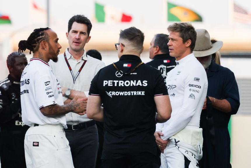 Lewis Hamilton, Brad Pitt and Joseph Kosinski, director of "F1 the Movie," talking on set ahead of the Abu Dhabi Grand Prix at Yas Marina Circuit on December 5, 2024.