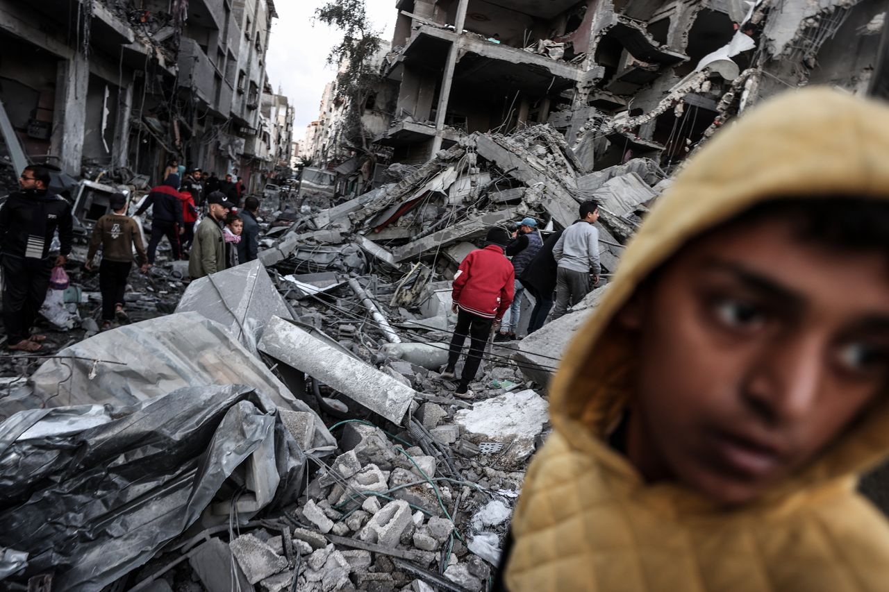 Palestinians inspect the targeted building and surrounding structures that were struck after an Israeli attack on Nuseirat refugee camp in Gaza, on December 13.