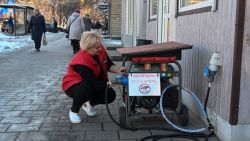 A woman starts an electric generator during a power outage in the western Ukrainian city of Lviv on December 13, 2024, amid the Russian invasion of Ukraine. Russia launched one of its largest missile attacks ever in the early hours of December 13, 2024, targeting Ukraine's energy grid as temperatures dropped below freezing, in what Moscow called a retaliatory strike for Kyiv firing US weapons on a southern Russian airfield earlier this week. (Photo by YURIY DYACHYSHYN / AFP) (Photo by YURIY DYACHYSHYN/AFP via Getty Images)