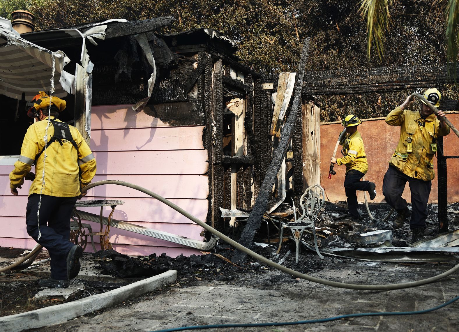 Firefighters work at a burned home in Malibu on Tuesday.