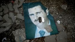 A damaged portrait of Syria's ousted president Bashar al-Assad lies on the ground in the western Syrian port city of Latakia on December 15, 2024. Islamist-led rebels took Damascus in a lightning offensive on December 8, ousting president Bashar al-Assad and ending five decades of Baath rule in Syria. (Photo by Ozan KOSE / AFP) (Photo by OZAN KOSE/AFP via Getty Images)