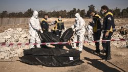 TOPSHOT - Members of Syria's White Helmets civil defence transport body-bags containing human remains that were recovered from a mass grave, in Damascus, on December 16, 2024. Islamist-led rebels took Damascus in a lightning offensive on December 8, ousting president Bashar al-Assad and ending five decades of Baath rule in Syria. According to the Syrian Observatory for Human Rights, more than 100,000 people died in Syria's jails and detention centres from 2011. (Photo by Aris MESSINIS / AFP) (Photo by ARIS MESSINIS/AFP via Getty Images)