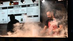 A chef cooks at a street-food stall on a Christmas-themed market in Manchester, northern England on December 16, 2024. (Photo by Paul ELLIS / AFP) (Photo by PAUL ELLIS/AFP via Getty Images)