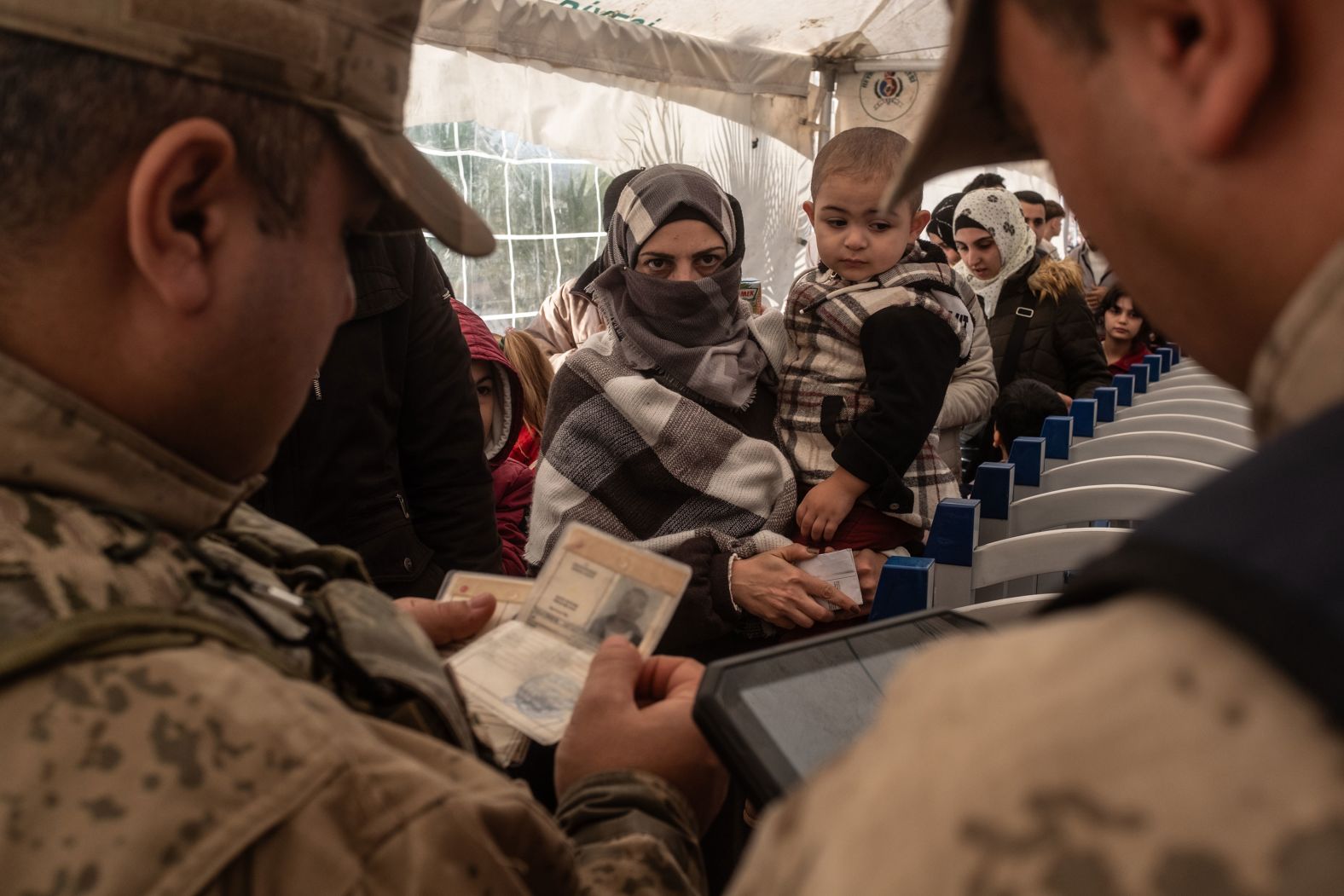 Syrian families living in Turkey get their documents checked at the Cilvegozu border gate as they wait to cross into Syria on December 13.