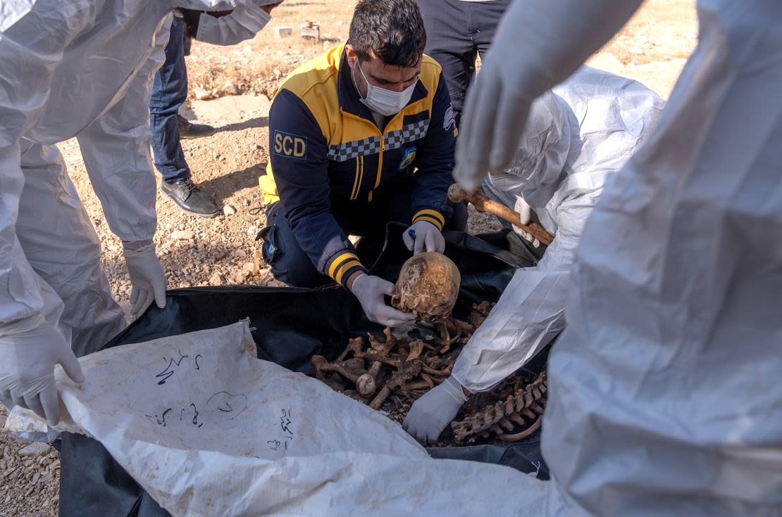 Miembros de la defensa civil siria Cascos Blancos trabajan en una fosa común donde se encontraron restos de cuerpos que se cree que son de civiles abatidos por el régimen derrocado de Bashar al-Assad, en la zona del puente de Bagdad, a las afueras de la capital, Damasco, Siria, el martes.