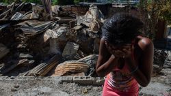 TOPSHOT - A woman cries outside her house after armed gangs set it on fire in the Post Marchand neighborhood of Port-au-Prince on December 17, 2024. (Photo by Clarens SIFFROY / AFP) (Photo by CLARENS SIFFROY/AFP via Getty Images)