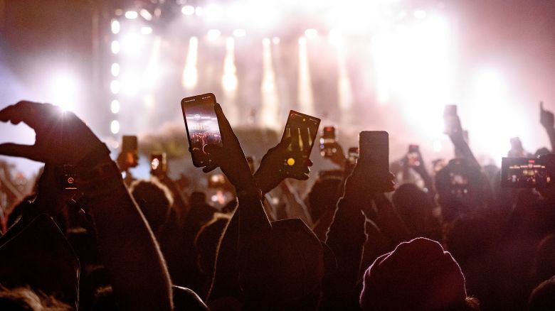 MIAMI GARDENS, FLORIDA - DECEMBER 14: People film Travis Scott on their mobile phones from the crowd during the 10th Annual 2024 Rolling Loud Music Festival at Hard Rock Stadium on December 14, 2024 in Miami Gardens, Florida. (Photo by Ivan Apfel/Getty Images)