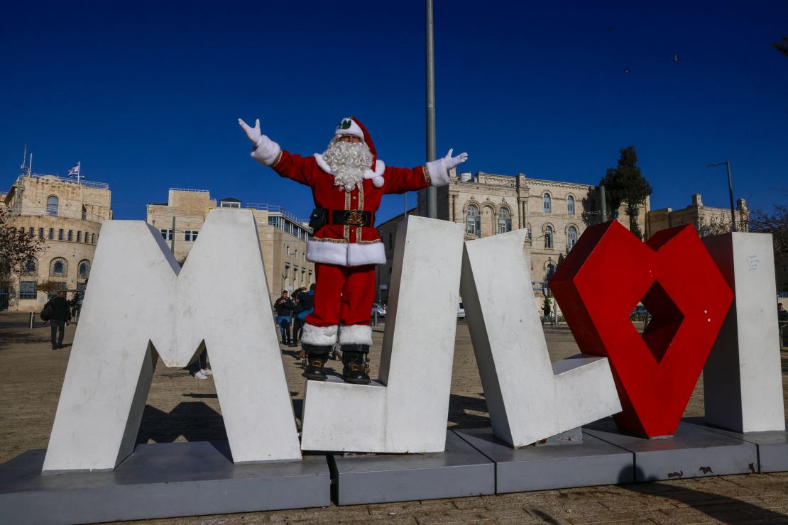 Palestinian man Issa Kassissieh, dressed as Santa Claus, poses for a photo at Jaffa Gate in Jerusalem's Old City on December 19, 2024.