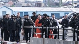 NEW YORK, NEW YORK - DECEMBER 19: Luigi Mangione, suspect in the killing of UnitedHealthcare CEO Brian Thompson in New York City, arrives at a heliport with  of the NYPD on December 19, 2024 in New York City. The 26-year-old was arrested in Pennsylvania on December 9 after being spotted at a McDonald's in Altoona amid a national manhunt. Mangione also appeared in a Pennsylvania court on forgery and firearms charges today, where he waived extradition to New York after being indicted on 11 charges including first-degree murder in furtherance of terrorism. (Photo by Stephanie Keith/Getty Images)