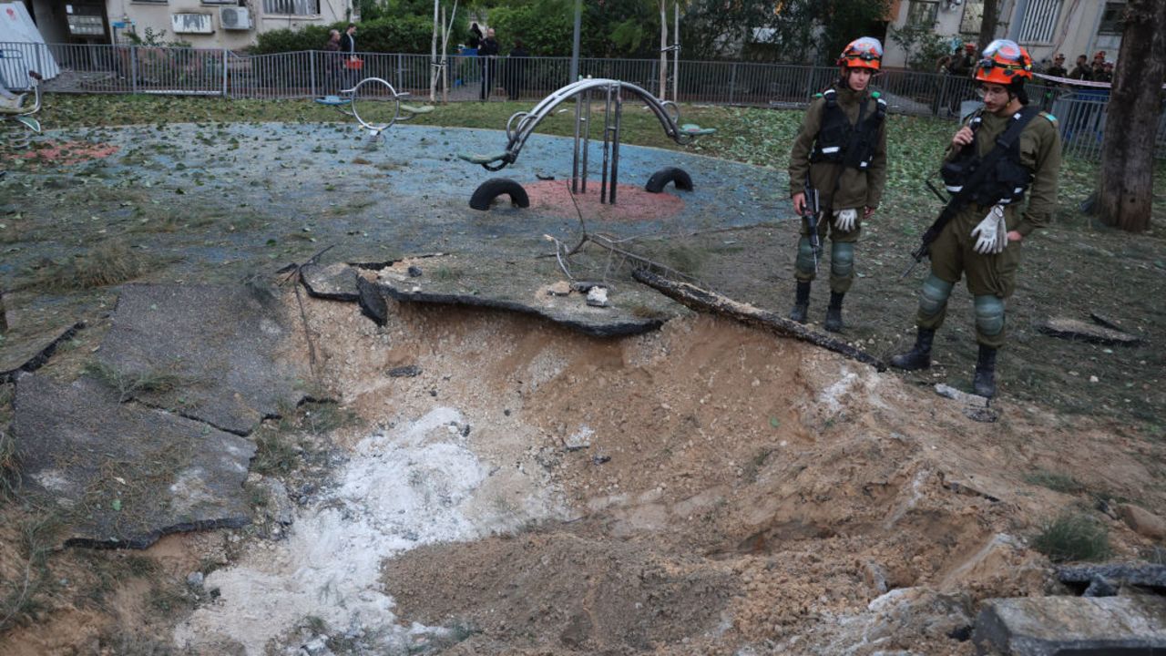 Israeli emergency responders inspect a crater at the site where a projectile fired from Yemen landed, in Tel Aviv early on December 21, 2024. Israel's military said on December 21, it had failed to intercept a "projectile" launched from Yemen that landed in Tel Aviv, with the national medical service saying 16 people were lightly wounded. Yemen's Iranian-backed Huthi rebels have repeatedly launched missile attacks against Israel since the war in Gaza began more than a year ago, most of which have been intercepted. (Photo by Jack GUEZ / AFP) (Photo by JACK GUEZ/AFP via Getty Images)