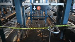 Police take security measures at the scene where a woman died after being lit on fire by a man aboard a subway train as she slept.